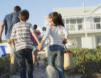 family walking back to vacation rental from the beach