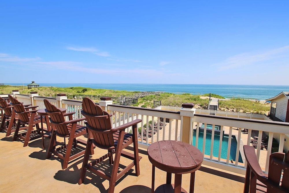 chairs around a pool deck overlooking ocean in outer banks