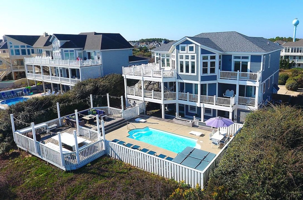 exterior view of outer banks family vacation rental showing private pool and outdoor dining area